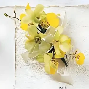 Ramo de solapa con orquídeas amarillas y cintas decorativas, ideal para eventos de gala.
