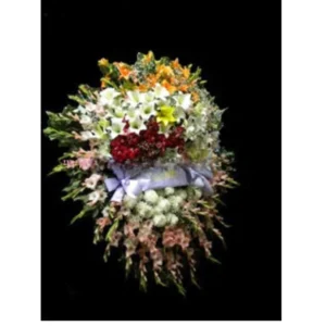 Corona floral vertical de tres niveles con flores variadas y cinta blanca para dedicatoria