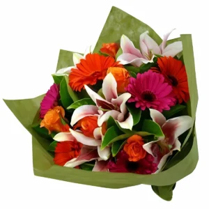 Ramo de flores coloridas con lirios rosados, rosas naranjas y gerberas rojas y fucsias, envuelto en papel verde. Ideal para celebraciones y regalos alegres.