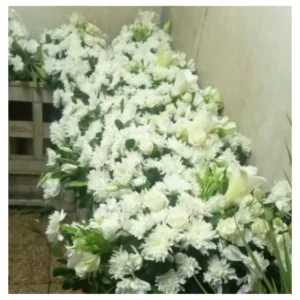 Arreglo flores blancas con rosas, lirios y crisantemos en diseño amplio y abundante, una composición elegante y distinguida ideal para ceremonias, recepciones y eventos especiales.
