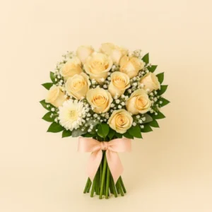 Ramo Rosas Crema con rosas en tonos cálidos, gypsophila blanca, follaje verde, tallos visibles y moño satinado durazno, sobre fondo claro. Composición vertical, suave y armoniosa.