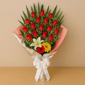 Ramo Rosas Impacto con rosas rojas, lirio amarillo, gerbera roja, gypsophila blanca, follaje verde, envoltura plateada y rosa, y lazo blanco satinado, sobre fondo beige y mesa clara. Composición vertical, vibrante y elegante.