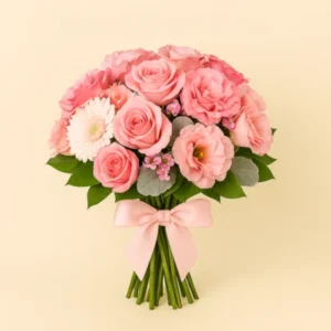 Ramo Tono Rosa con rosas pastel, gerberas blancas, lisianthus y follaje plateado, tallos visibles y moño satinado rosa, sobre fondo claro. Composición vertical, suave y equilibrada.