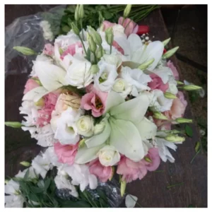 Ramo floral elegante con lirios blancos, rosas marfil y lisianthus rosados en una composición equilibrada y sofisticada, ideal para bodas, regalos y celebraciones especiales.