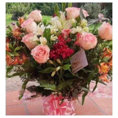 Ramo rosas rosas acompañado de lirios, alstroemerias y flores rojas en diseño equilibrado con follaje verde y lazo decorativo, un arreglo elegante y luminoso ideal para regalar y decorar celebraciones.